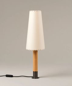 a lamp that is on top of a white surface with a black cord attached to it