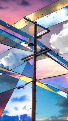 an image of a telephone pole with birds sitting on it and clouds in the background