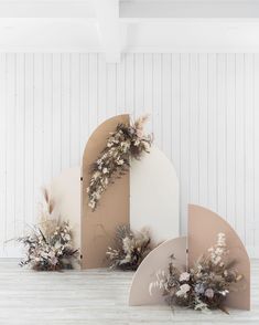 an assortment of flowers are placed on top of cardboard boxes in front of a white wall