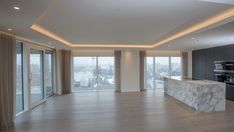 an empty kitchen with marble counter tops and large glass doors leading to the balcony area