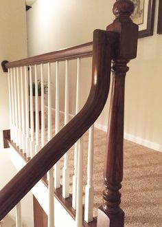 a wooden banister next to a carpeted floor