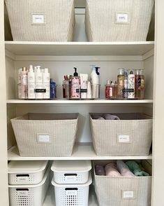 an organized closet with white baskets and toiletries