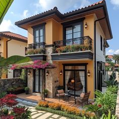 a house that is painted yellow and has flowers on the balconies