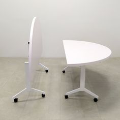 two white tables sitting next to each other on wheels