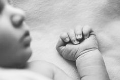 a black and white photo of a baby's hand