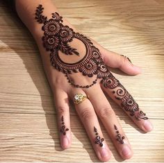 a woman's hand with henna tattoos on it