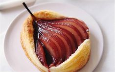 a pastry on a white plate topped with jelly