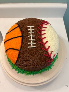 a cake decorated to look like a football, basketball and soccer ball on a plate