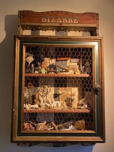 an old fashioned display case with many items in it