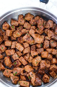 a pan filled with meat and sauce on top of a table