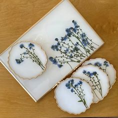 three plates with blue flowers on them sitting on a wooden table next to a box