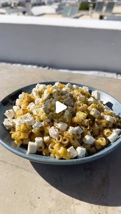 a bowl filled with food sitting on top of a table next to a window sill