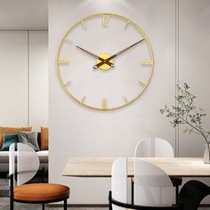 a large clock mounted to the side of a wall in a living room next to a dining table