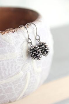 "These are rustic nature inspired antiqued silver rhodium pine cone earrings! These little drop earrings have beautiful details highlighted by the antiqued silver over brass finish! These earrings are nickel free and lightweight, making them great for everyday wear. The fish hook ear wires are surgical steel. These earrings measure approximately 1\"(26mm) long and the pine cone charm is approximately .5\" (12mm).  These are available in ANTIQUED Rose Gold , ANTIQUED gold. These are also availabl Pine Cone Earrings, Pinecone Earrings, Pine Cone Wedding, Nature Jewellery, Bridesmaid Pearl Earrings, Small Drop Earrings, Bridal Party Jewelry, Earrings Nature, Felt Jewelry