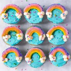 cupcakes with blue frosting and rainbow decorations