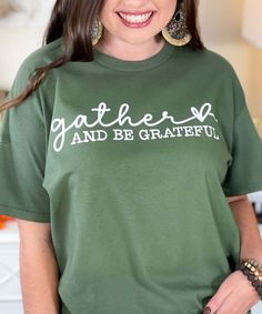 Embrace the spirit of Thanksgiving with the Gather And Be Grateful Graphic Shirt. Featuring the heartfelt phrase "Gather And Be Grateful" in elegant white lettering, this shirt is a perfect reminder of the importance of togetherness and gratitude during the holiday season. Available in sizes YXS-5XL and in your choice of color, this shirt is both comfortable and stylish, making it ideal for family gatherings, Thanksgiving dinners, or any occasion where gratitude is celebrated. Wear it to spread Positivity Shirts, Thanksgiving Dinners, Positive Shirt, Be Grateful, Graphic Shirt, Family Gatherings, Family Gathering, The Spirit, Graphic Shirts