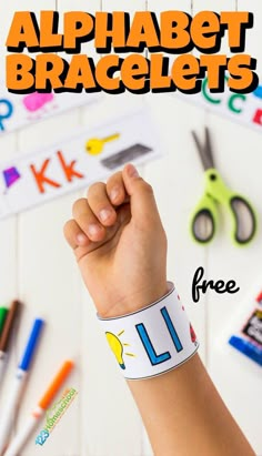 a kid's hand holding onto a wristband with the words alphabet bracelets on it