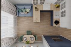 an overhead view of a small kitchen and living room in a tiny apartment with wood flooring