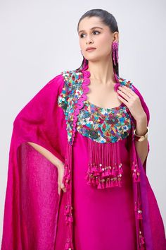 Rani pink asymmetric tunic with multi colored embellished yoke and tassel drops. Comes with matching tasseled and corded crushed cape. - Aza Fashions Fitted Pink Kaftan, Fitted Pink Bohemian Kaftan, Pink Fitted Bohemian Kaftan, Bohemian Pink Party Sets, Festive Fitted Pink Kaftan, Pink Sleeveless Bohemian Sets, Pink Silk Bohemian Sets, Pink Silk Sleeveless Set, Neck Shapes