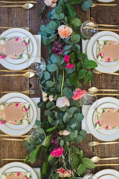 the table is set with flowers and plates