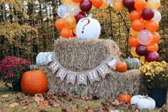 a hay bale with pumpkins and balloons on it