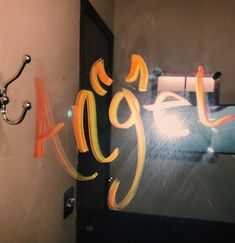 the reflection of a bathroom door with graffiti on it