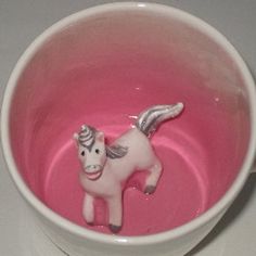 a pink cup with a white horse in it