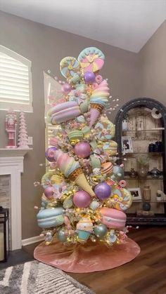 a decorated christmas tree in the middle of a living room with pink and blue decorations