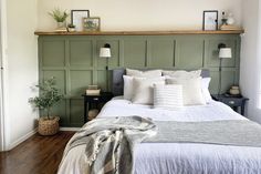 a bed with white linens and pillows in a bedroom next to a wooden headboard