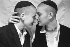 two people are smiling and touching each other's foreheads in black and white