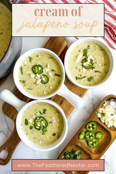 three bowls of cream of jalapeno soup on a cutting board with spoons