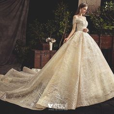 a woman in a wedding dress standing next to a table with flowers and greenery