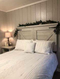 a bed with white linens and pillows in a small room decorated for christmas or new year's eve