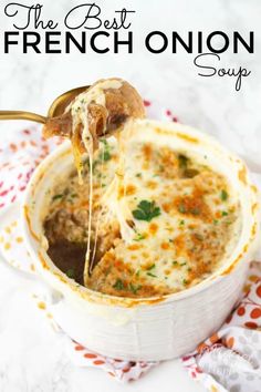 a spoon full of soup being lifted from a white bowl with meatballs in it