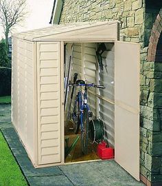 an outdoor storage shed with two bicycles in it