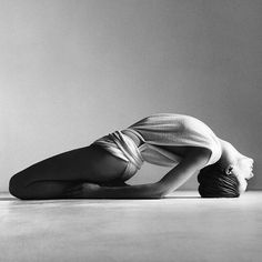 a black and white photo of a woman laying on the floor with her head down