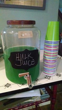 a glass jar with a chalkboard label on it sitting on a table next to cups