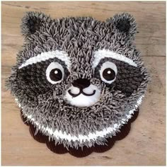 a cupcake shaped like a raccoon on top of a wooden table