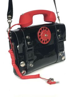 30% OFF WAS $250 NOW $175 Industrial design, wearable art Fashionista Steampunk black leather bag in telephone design. True piece of art and conversation starter. Size is designed to accommodate standard tablet.] Handmade item. Bag material PU coated leather Retro telephone decorative handle Aluminum telephone dail ,with hi tek logo. Width 29.50 cm or 11 4/8 inches Height without the telephone 21 cm or 8 2/8 inches Designer Black Satchel With Mobile Phone Bag, Vintage Black Satchel With Mobile Phone Bag, Designer Black Bags With Hardware, Retro Telephone, Steampunk Black, Telephone Design, Black Leather Bag, Novelty Bags, Vintage Purses