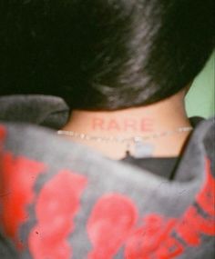 the back of a woman's neck with a tattoo on it that reads rare