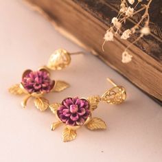 This lovely earrings are really cute, made of a resin handpainted purple-pink flower in a golden rose base. Gold plated filigree post earrings. Size from your piercing: 3.5 cms ( 1.30 Inches) Please note my jewelry is not waterproof, please avoid bathing and perfumes.  Please note the colors could vary slightly on each screen. If you have any question feel free to ask me! Your order comes in a gift box or a gift bag, so, it is ready for gift giving Thanks for looking! Valentine's Day Gift Drop Clip-on Earrings, Pink Pierced Earrings As Gift, Handmade Enamel Earrings For Party, Gold Enamel Flower Earrings For Gift, Handmade Enamel Earrings For Wedding, Pink Enamel Flower-shaped Earrings, Enamel Clip-on Earrings As Gift, Vintage Hand Painted Pink Jewelry, Nickel-free Enamel Flower Earrings Gift