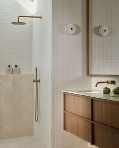 a bathroom with white tile and wooden cabinets