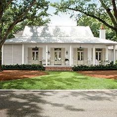 a white house surrounded by trees and grass