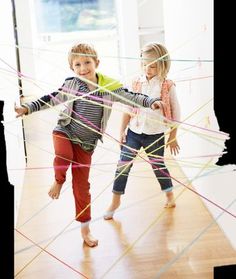 two young children are playing with string art