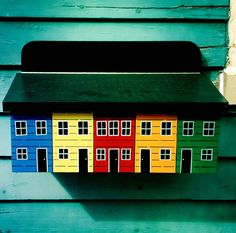 a mailbox with colorful houses painted on it