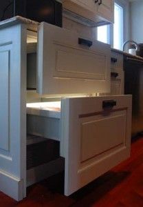 a kitchen with white cabinets and drawers in it