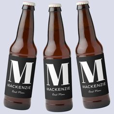 three bottles of mackenzie beer on a gray background with the letter m in black and white