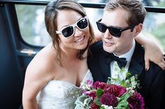 a bride and groom are sitting in the back of a limo with their arms around each other