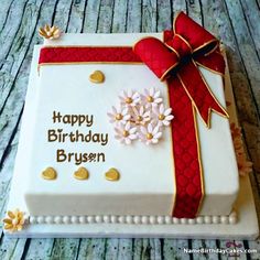 a birthday cake that is decorated with flowers and a red ribbon on the top, says happy birthday to you zaheeer