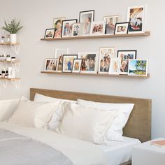 a bed with white sheets and pictures on the wall